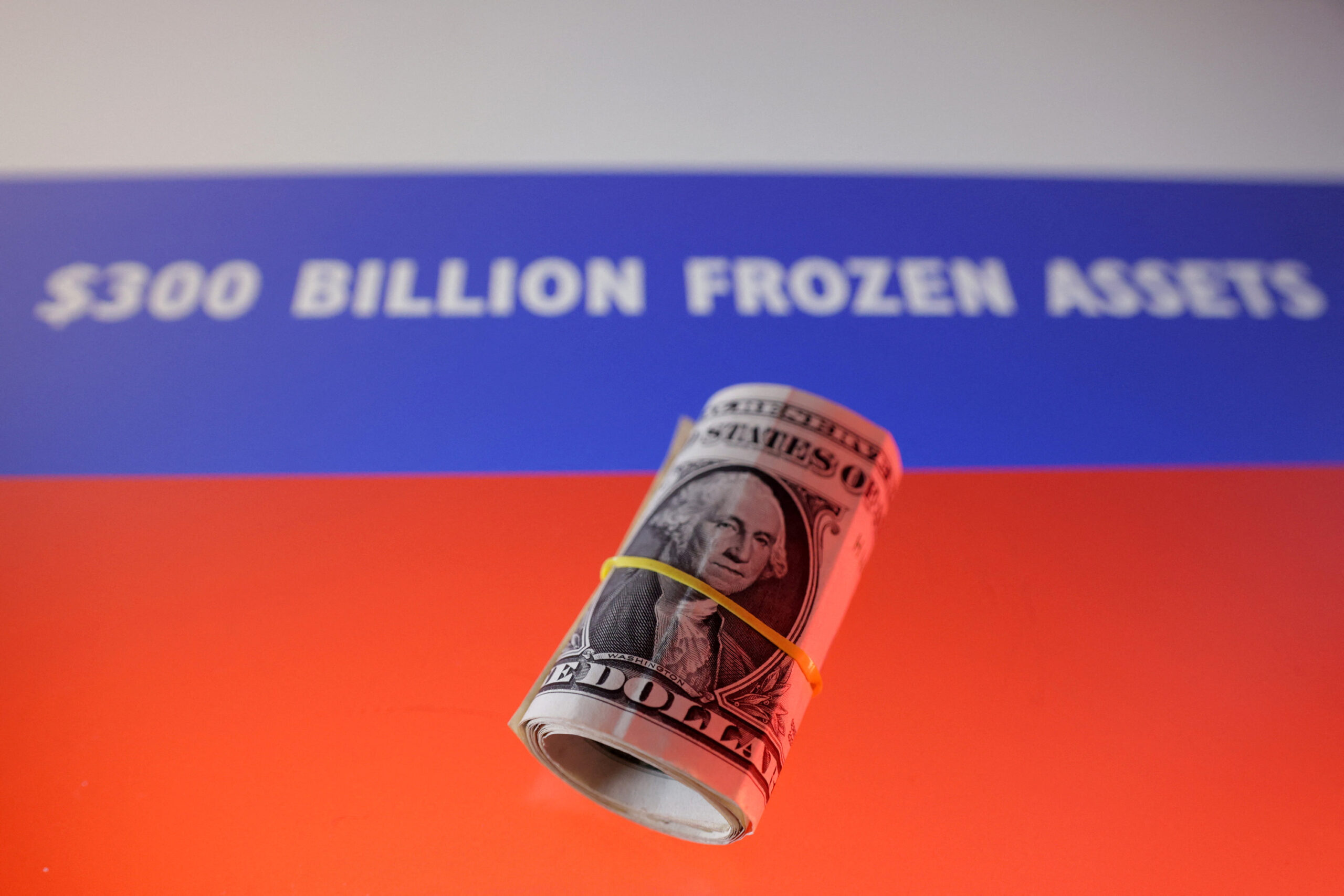 Dola ya Marekani iliyofungwa kwa mpira wa manjano ikiwa mbele ya maandishi $300 BILLION FROZEN ASSETS, ikiwakilisha mali za Urusi zilizozuiwa na mataifa ya Magharibi